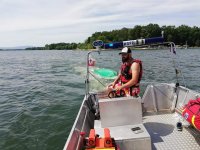 Ratownicy WOPR holują przewróconą łódź