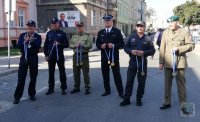 Panowie komendanci z Policji, Straży Pożarnej, Służby Leśnej stoją i trzymają medale