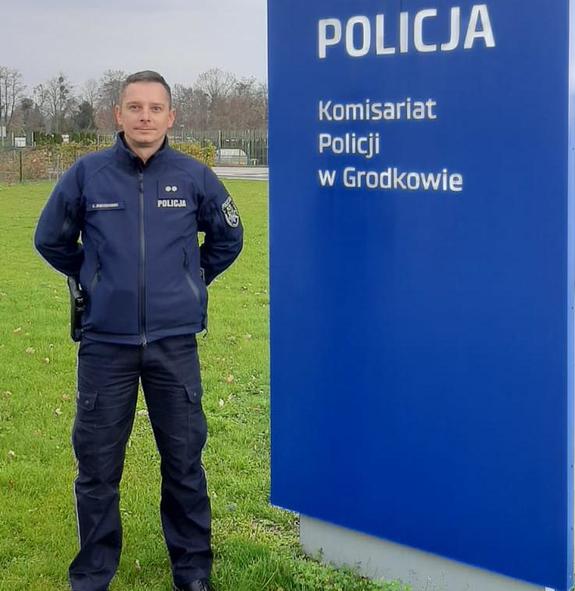 policjant obok baneru