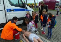 Dzieci uczą się udzielać pierwszej pomocy pod okiem policyjnego ratownika medycznego.