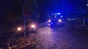 na zdjęciu volkswagen lupo oraz policyjny radiowóz, noc