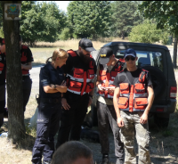 Policjanci i ratowniczy grupy poszukiwawczej oczekują na komendę do wyruszenia w teren