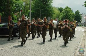 Orkiestra wojskowa z Bytomia gra marsza podczas przemarszu na cmentarz komunalny w Oleśnie.