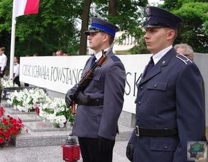 Policjant z karabinkiem stoi na warcie honorowej przy pomniku Powstańców Śląskich
