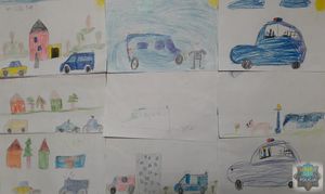 prace plastyczne ułożone obok siebie  narysowane przez dzieci przedstawiające pojazdy policyjne
