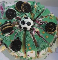 Tort w kolorze zielonym z dekoracją w kształcie piłki nożnej.