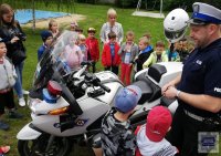 Policjant ruchu drogowego prezentujący dzieciom motocykl