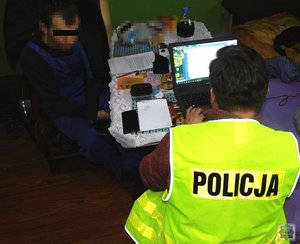 kryminalny sprawdza komputer zatrzymanego