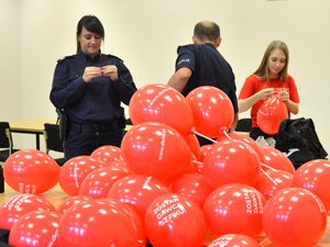 czerowne balony DKMS w tle policjanci i wolontariusze