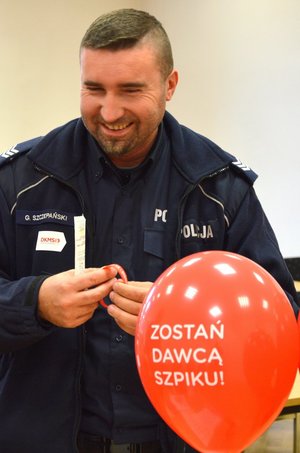 policjant uśmiecha się i wypełnia ankietę DKMS