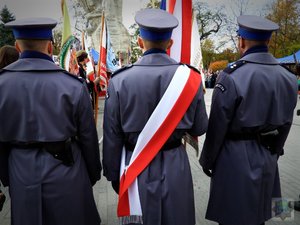 poczet sztandarowy KWP Opole - 3 policjantów stoją plecami do obiektywu