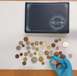 Na zdjęciu album numizmatyczny wraz z monetami