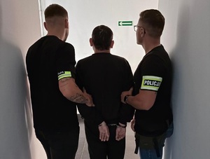 zdjęcie kolorowe: policjanci z zatrzymanym mężczyzną