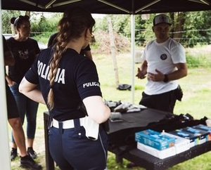 kolorowe zdjęcia na których widać funkcjonariuszy podczas szkolenia z zakresu pierwszej pomocy i korzystania ze staz taktycznych, tamowania krwotoków.