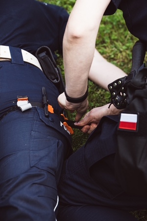 kolorowe zdjęcia na których widać funkcjonariuszy podczas szkolenia z zakresu pierwszej pomocy i korzystania ze staz taktycznych, tamowania krwotoków.