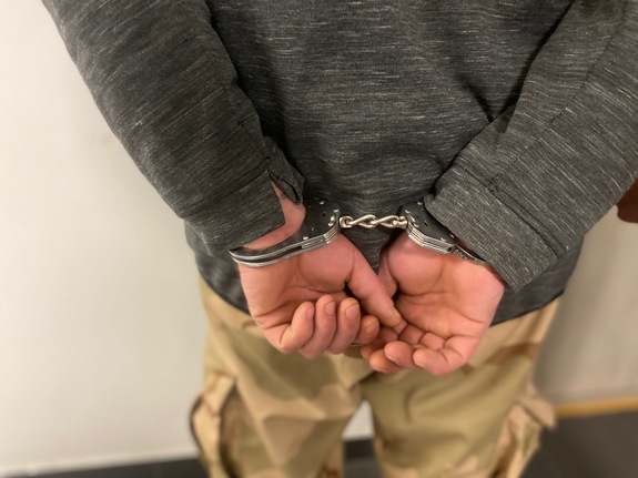 kolorowa grafika, dłonie mężczyzny z kajdankach