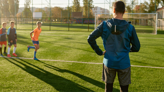 trener na boisku sportowym z zawodnikami