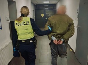 mężczyzna prowadzony przez policjantkę