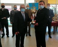 Sekretarz Urzędu Miejskiego w Głuchołazach stoi obok zwycięzcy turnieju szachowego , który trzyma otrzymany puchar w ręce