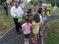 Organizatorzy pikniku rozdają dzieciom odblaskowe worki wraz z upominkami