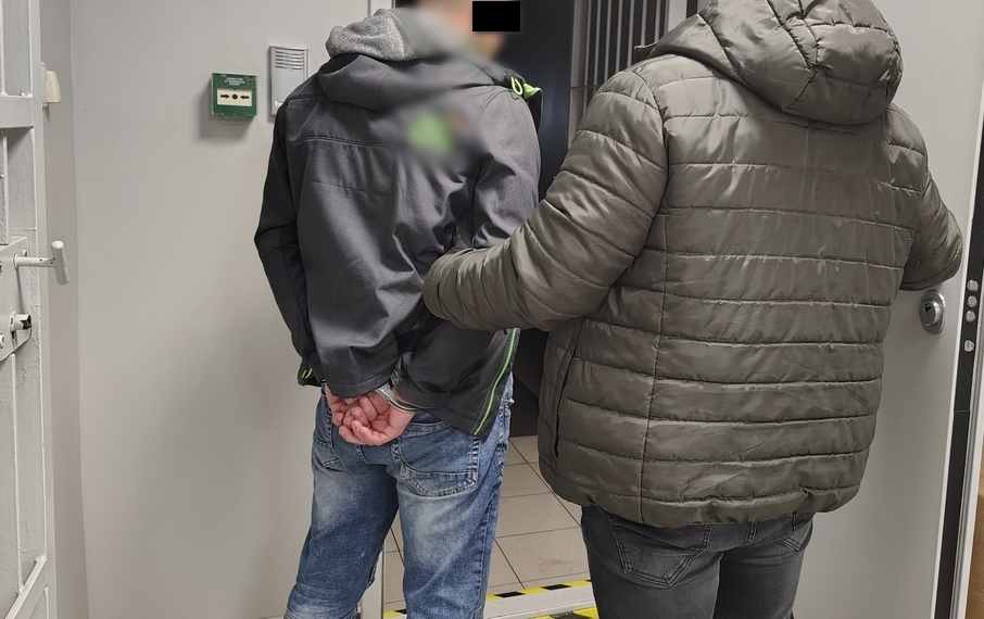 policjant prowadzi zatrzymanego