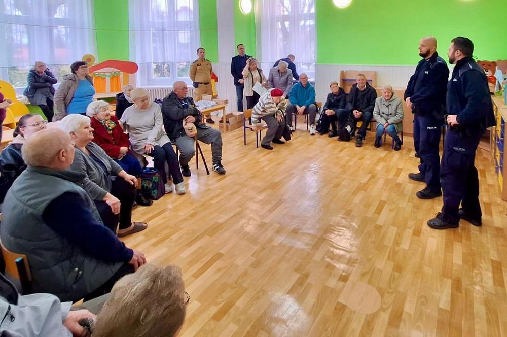 policjanci rozmawiają z grupą seniorów
