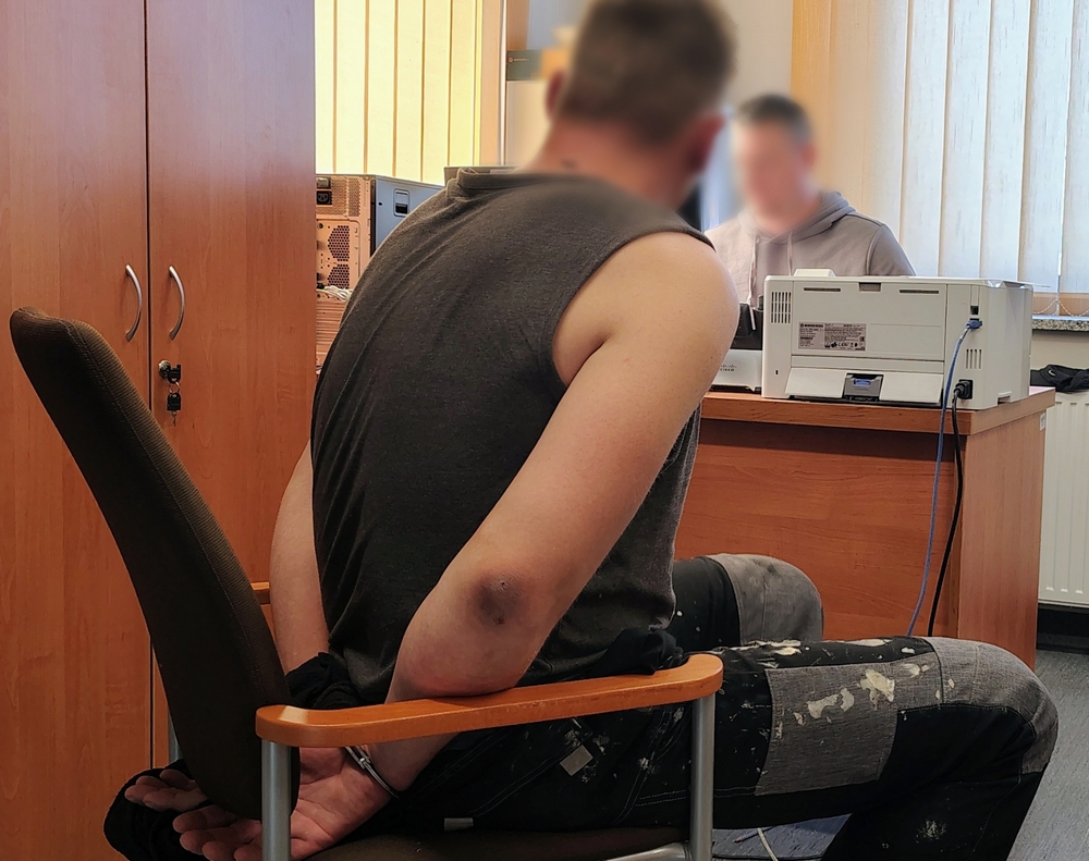 policjant przesłuchuje zatrzymanego