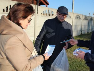 mundurowi przekazują materiały promocyjne i maseczki ochronne