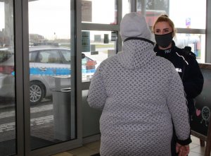 policjantka w maseczce zakrywającej nos i usta rozmawia z kobietą