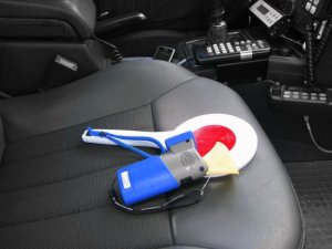 urządzenie do badania stanu trzeźwości i policyjna tarcza do zatrzymywania pojazdów na fotelu w radiowozie