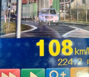 zdjęcie z radaru prędkości, na którym widać biały pojazd i prędkość 108km/h.