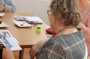 seniorzy czytają broszury informacyjne