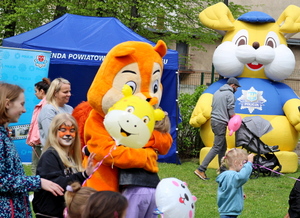 na placu uczestnicy festynu, niebieski namiot obok maskotka żółty królik