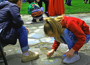 dzieci malujące kredą na płytach chodnikowych