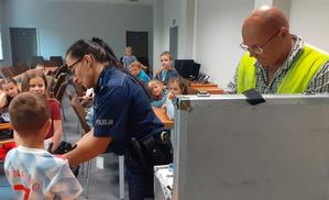 policjanci pokazują dzieciom walizkę technika kryminalistyki