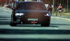 zrzut ekranu z ręcznego miernika prędkości na którym widać czarny samochód