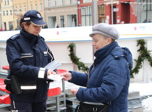policjantka przekazuje ulotki seniorce