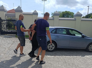 Policjanci prowadzą zatrzymanego