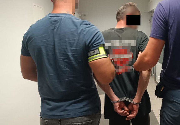 Policjanci prowadzą zatrzymanego