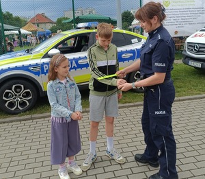 policjantka daje odblaski dzieciom