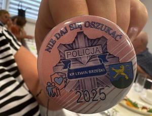 różowa przypinka z logiem komisariaty Policji