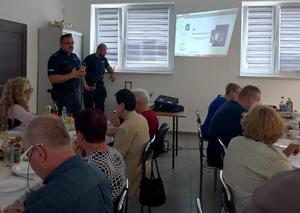 policjant rozmawia z grupą seniorów