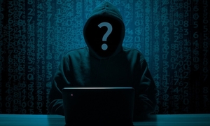 postać siedząca przed laptopem