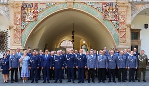 grupa policjantów z na tle zabytkowej bramy z muzeum