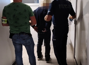 policjanci prowadzą zatrzymanego