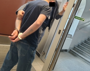 policjant prowadzi zatrzymanego