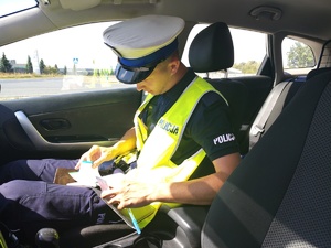 policjant w radiowozie wypełnia dokumenty