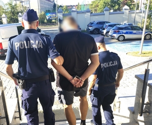 policjanci prowadzą zatrzymanego