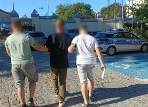 policjanci prowadzą zatrzymanego