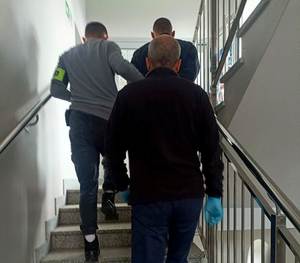policjanci prowadzą zatrzymanego